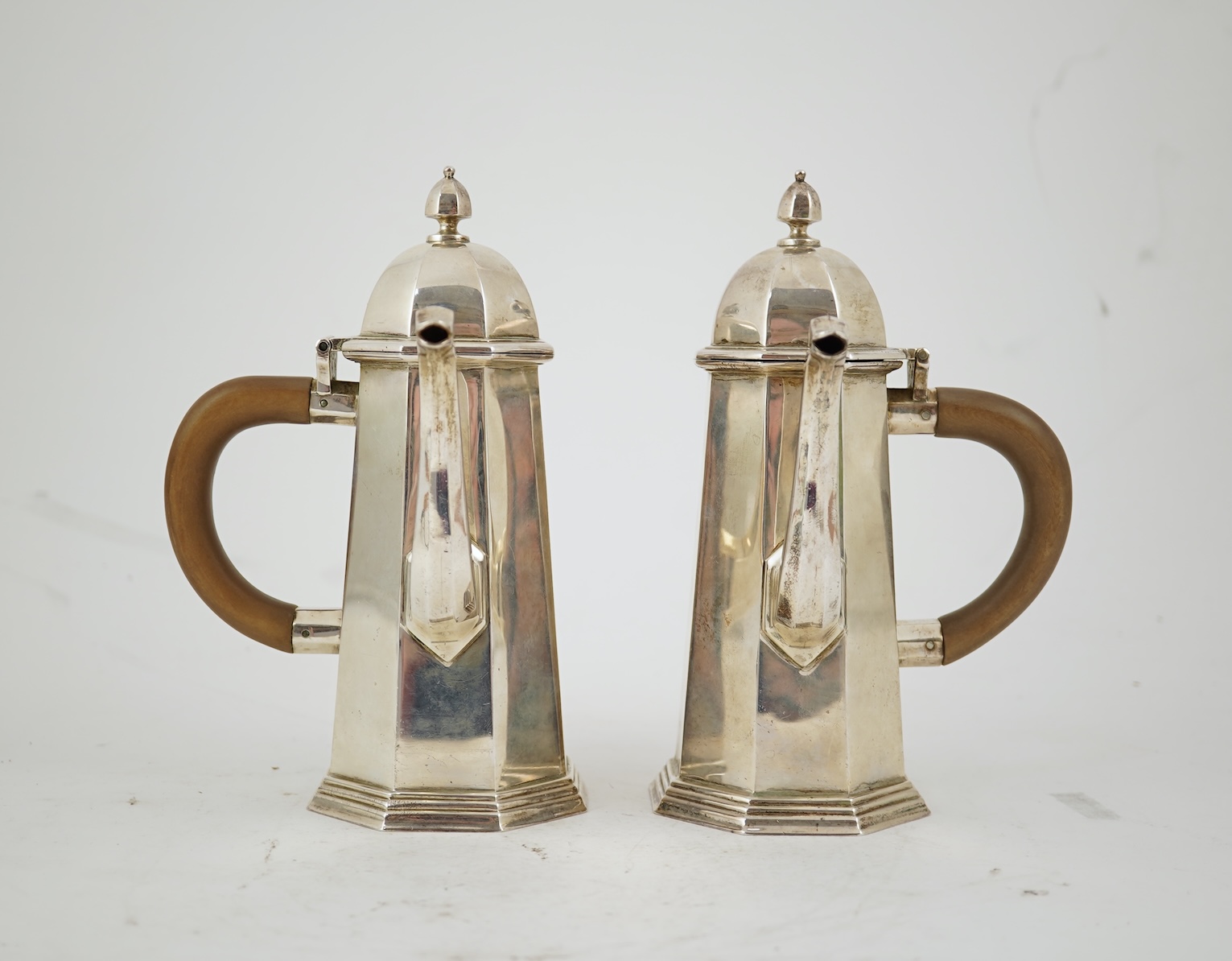 A pair of George V octagonal silver café au lait pots, by William Comyns & Sons Ltd